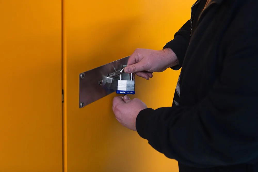 Customer placing a silver padlock on to a storage unit door.